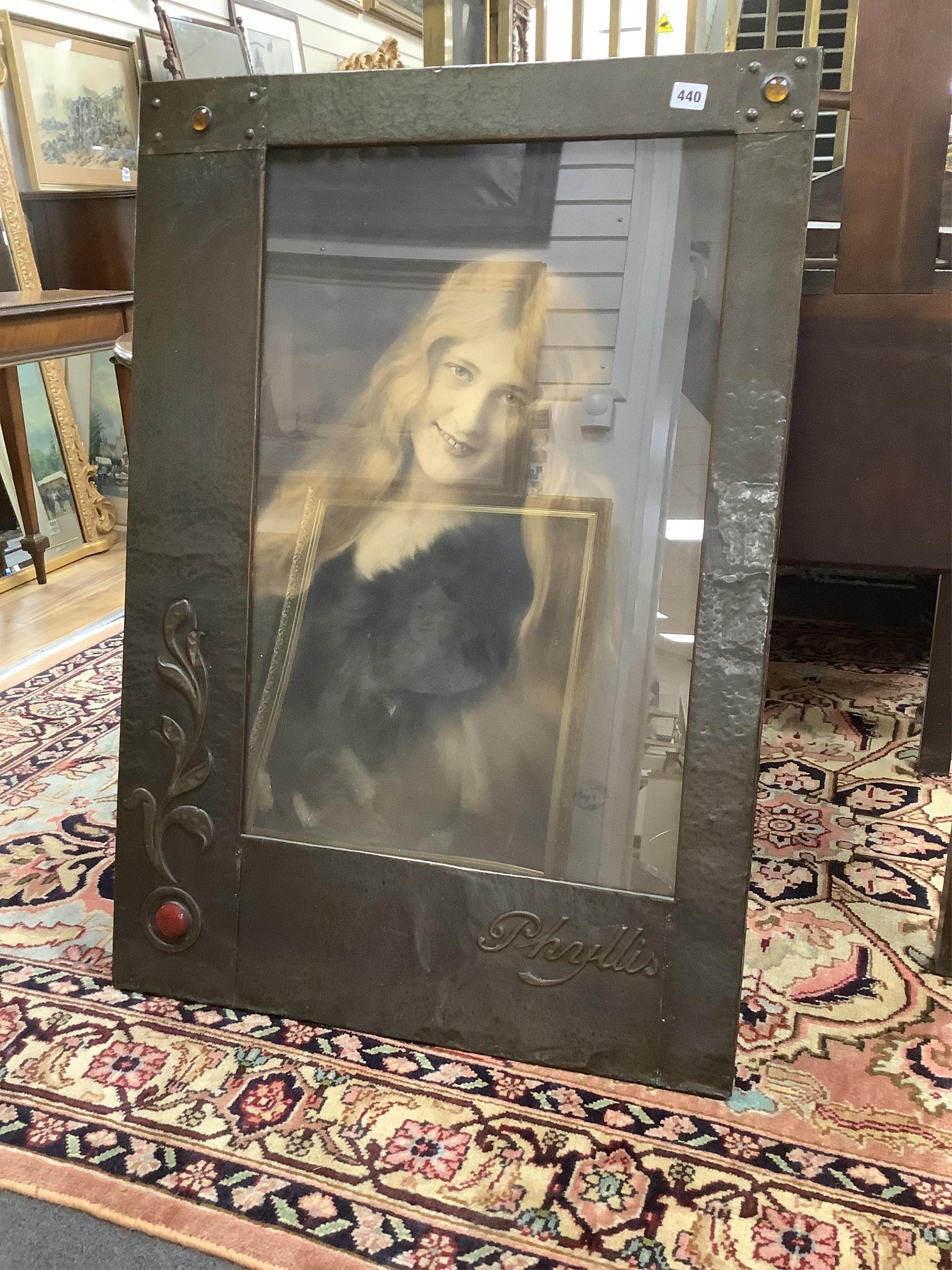 A large Arts & Crafts planished copper frame housing a photograph of Phyllis Dare, an early 20th century actress from Hove, taken by Louis Langfier, overall 100 x 70cm. Condition - fair to good